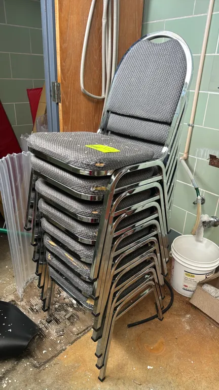 Upholstered stacking banquet chairs. Features gray patterned fabric padded seats and backrests on chrome-finished metal frames. Note: Multiple chairs