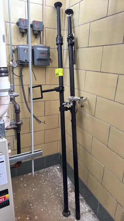 Telescopic lighting support poles. Features black metal construction with rubberized feet and adjustable locking collars. Includes one mounted frame b