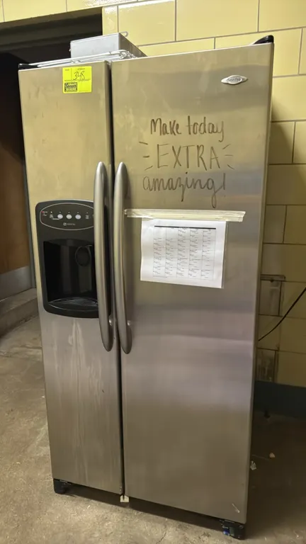 Maytag MSD2355HES side-by-side refrigerator. Features stainless steel finish, in-door water and ice dispenser, adjustable glass shelving, and pull-out