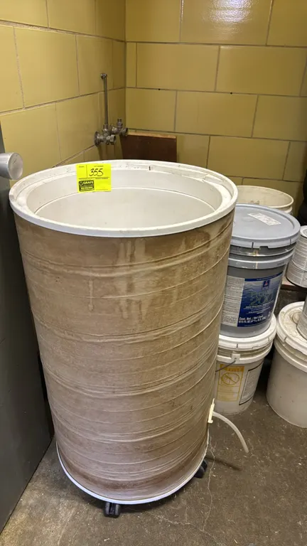 Portable poly tub. Features cylindrical plastic construction, white interior liner, and a bottom drain port with clear vinyl tubing. Mounted on a mobi