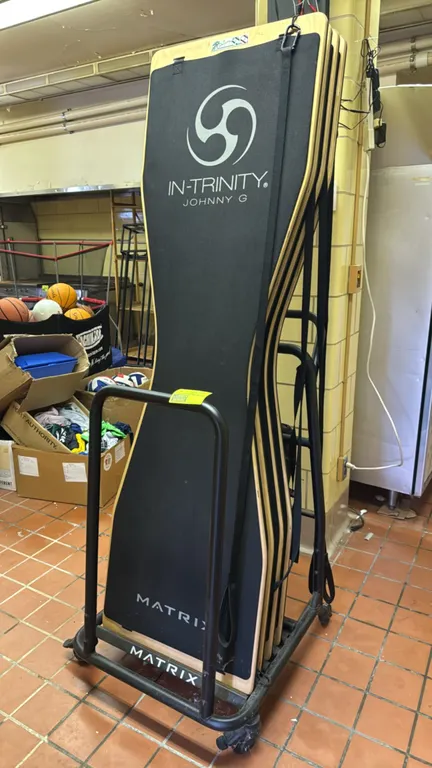 Matrix In-Trinity Johnny G training boards. Features wood construction with a black padded top surface and attached training straps. Mounted on a mobi