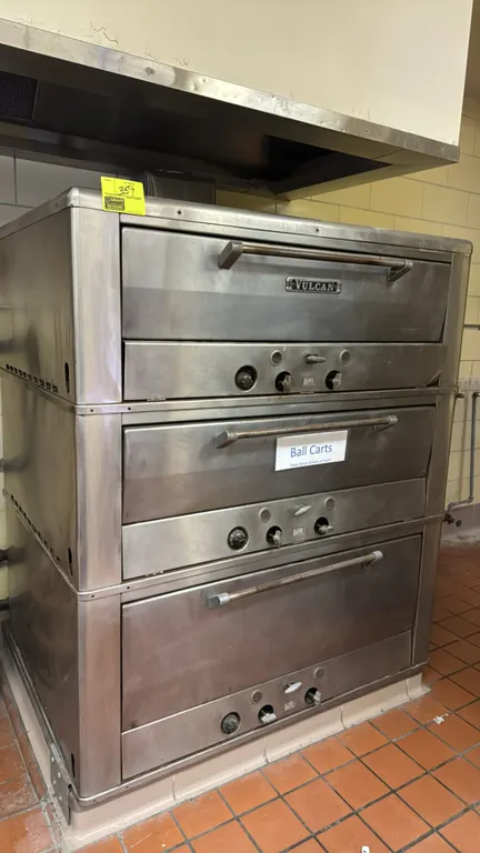 Vulcan natural gas 3-deck oven. Features stainless steel exterior construction, three stacked baking decks with drop-down doors, and individual deck c