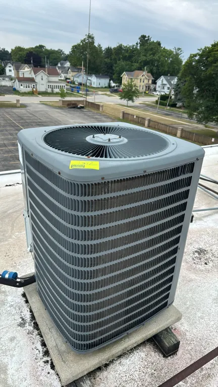 Goodman air conditioner condenser unit. Features a louvered metal cabinet and top-discharge fan. S/N: 1507306536. Electrical: 208/230V, 1-Phase, 60Hz.