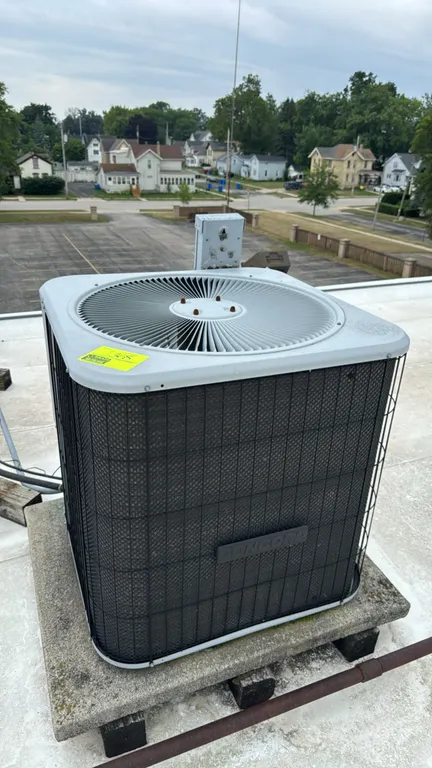 Concord rooftop air conditioner condensing unit. Features a top-discharge fan, metal protective grille, and attached electrical disconnect box. Note: