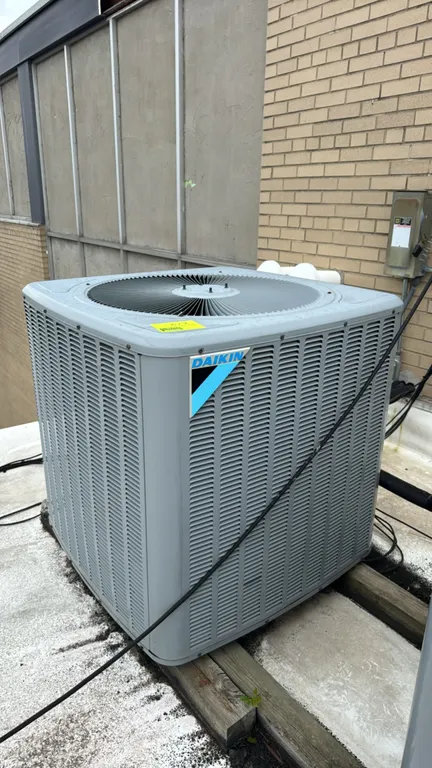 Daikin DX13SA0603AD air conditioner condensing unit. Features louvered coil guard and top-discharge fan. Uses R-410A refrigerant. S/N: 1906097986. Ele