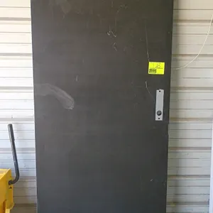 Steel door. Features a flush design with a dark gray finish and pre-cut lock prep. Dimensions: 36"W x 83"H. Note: Frame, hinges, and handle hardware n