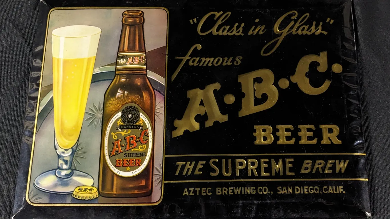 CELLULOID OVER TIN SIGN "CLASS IN GLASS" FAMOUS ABC BEER THE SUPREME BREW AZTEC BREWING SAN DIEGO CALIFORNIA