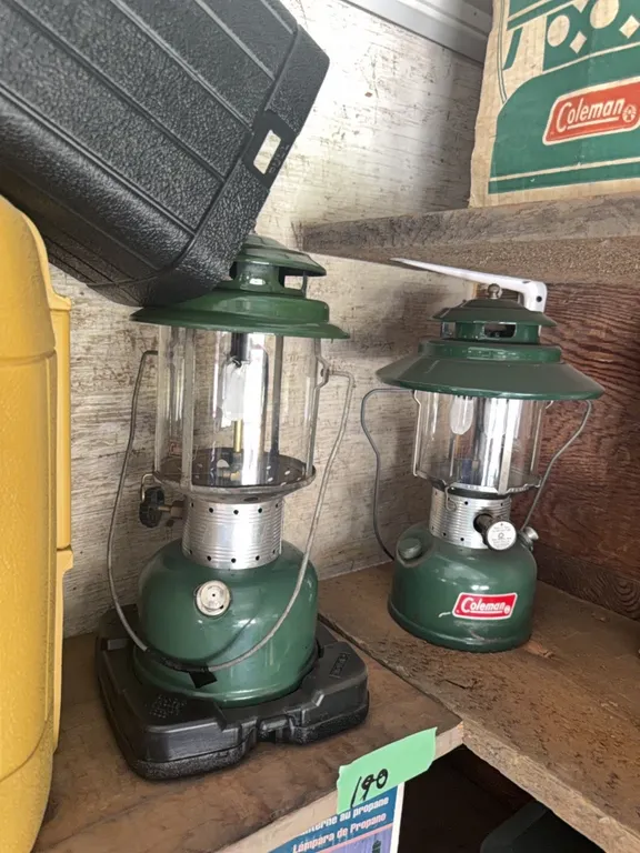 Two Coleman lanterns, either brand new or next to new