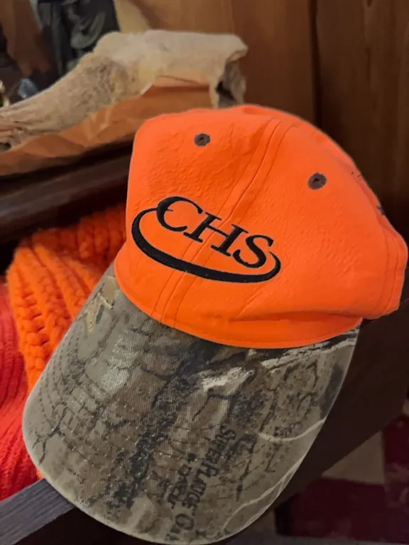 Top right drawer of antique dresser- orange beanie hats and CHS bill cap, coatzippers
