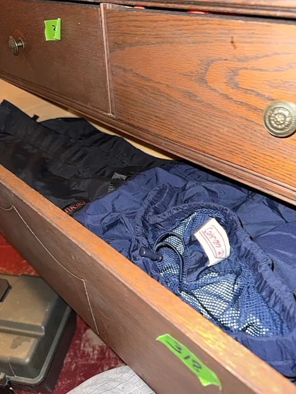 Second drawer of antique dresser. Pair of Kenetrek hunting gaiter, coleman rain pants