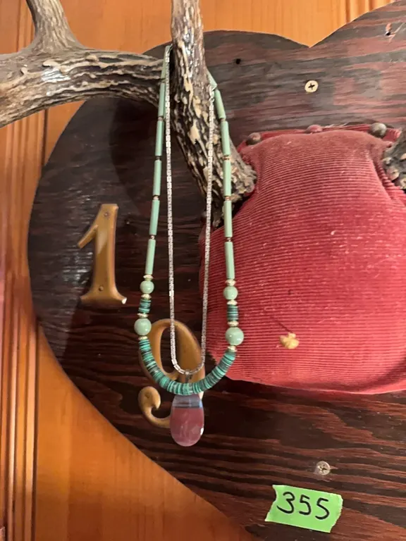 antlers with a variety of items hanging on it…necklaces and hats.. all goes