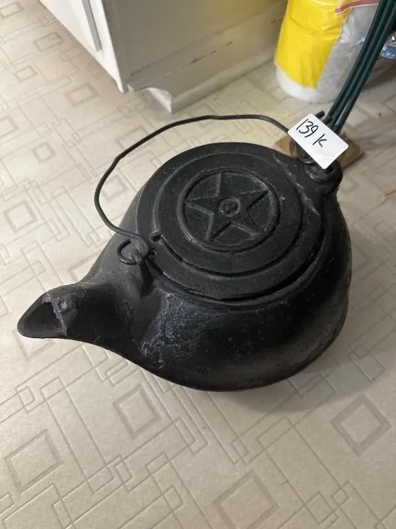 This vintage cast iron kettle features a