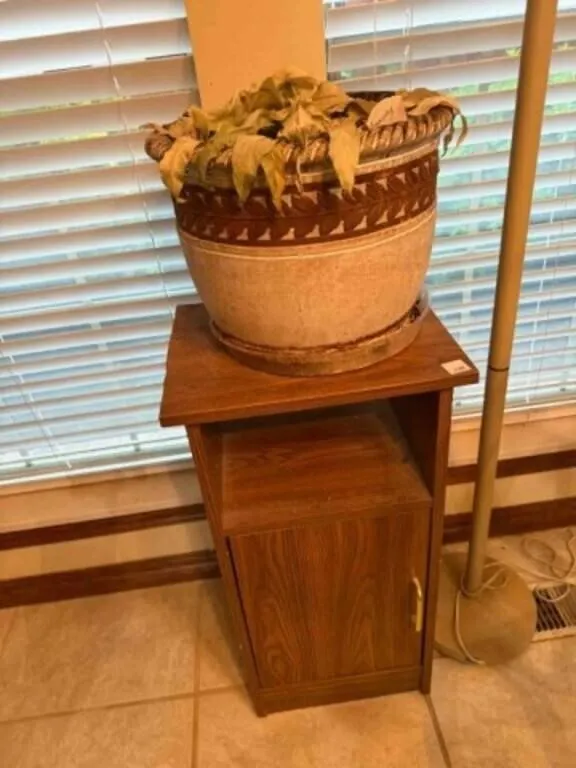 small wood cabinet and pole lamp