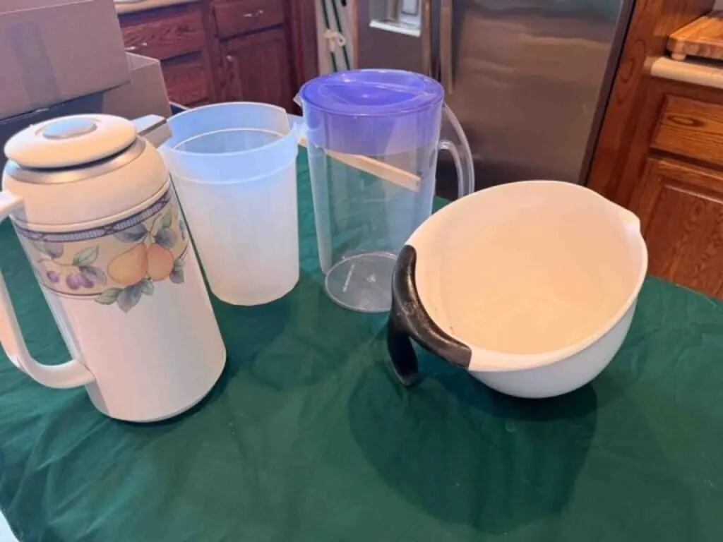 cabinet full of Ice maker, pitchers, etc