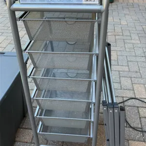 Utility package lot. Includes a 6-tier gray metal rolling organizer cart with mesh drawers, a folding metal clothes drying rack, and (3) boxes of Kirk