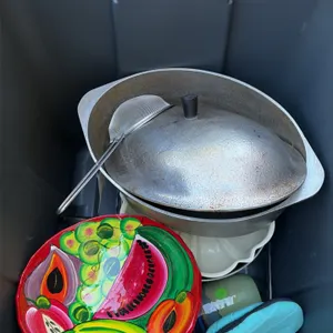 Assorted kitchen bakeware and roasting pan lot. Includes a large oval cast aluminum roaster with lid, white ceramic platter, hand-painted ceramic frui