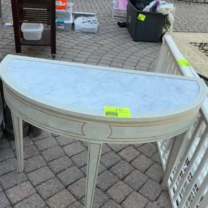 Modern History demilune console table. Features an inset white marble top and a painted frame with gold-tone line accents. Supported by three tapered 