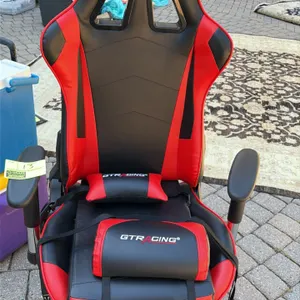GTRACING gaming office chair. Features red and black faux leather upholstery, adjustable armrests, and high-back design. Includes a matching removable
