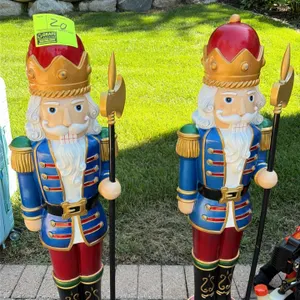 A Pair of Holiday Nutcracker Display Figures. (Unknown, 2010s) A pair of decorative nutcracker statues holding gold-colored halberds. Features molded 