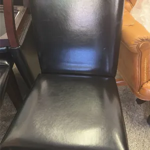 Dining room chairs. Features black vinyl upholstered seats and high backs. Mounted on dark brown wooden legs and frames. Armless design.
