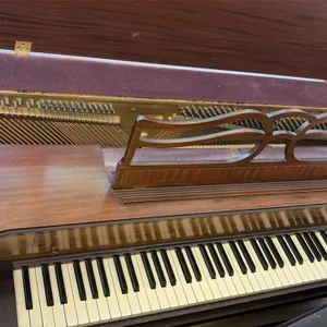 Baldwin upright acoustic piano. Features a wood cabinet, integrated folding music stand, fold-down keyboard cover, and three foot pedals. Includes a m