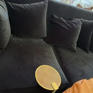 Unbranded black velvet upholstered sofa. Features a tuxedo-style design with high back and arms, five matching velvet toss pillows, and an attached br