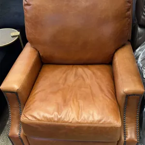 La-Z-Boy reclining armchairs. Features brown vinyl upholstery with double-stuffed cushioning. Accented with decorative nailhead trim on the rolled arm