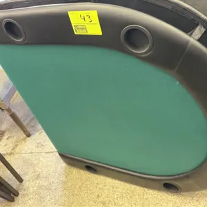 Fold-up poker table. Features a green felt playing surface, padded black vinyl armrest, and integrated cup holders. Folding design for compact transpo