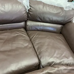 Leather sectional sofa set. Features dark brown leather upholstery, plush pillow-top back cushions, and rolled armrests. Includes two matching coordin