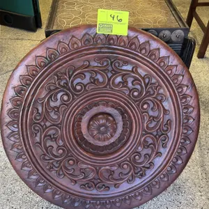 Wood decorative barrel top. Features an intricate carved floral and scroll medallion design on the front face. Reverse side is constructed of rustic w