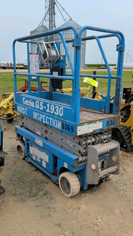 1999 Genie GS-1930 electric scissor lift. Features a 500 lbs capacity, platform extension, solid non-marking tires, and platform control box. Hour met