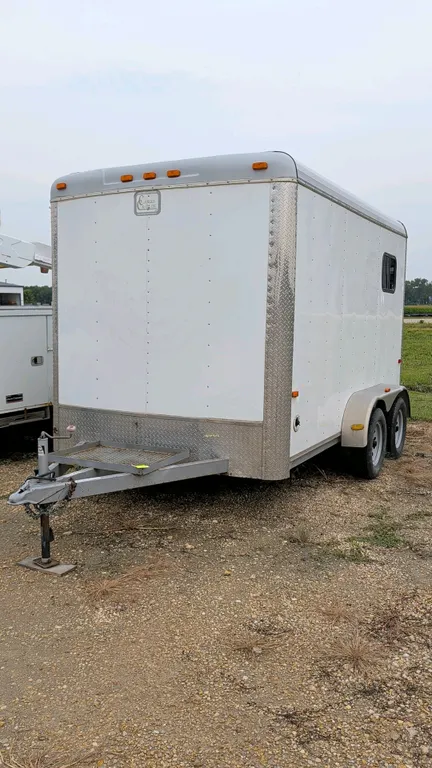 Cargo Craft Expedition enclosed bumper hitch trailer. Features twin axles, side walk-in door, rear single swing door, two windows, and two 16" square