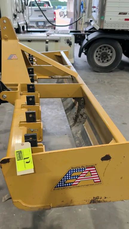 Everything Attachments 3-point box blade. Features adjustable scarifier shanks and dual cutting edges. 8'L. 3-point hitch mount. Tractor in background
