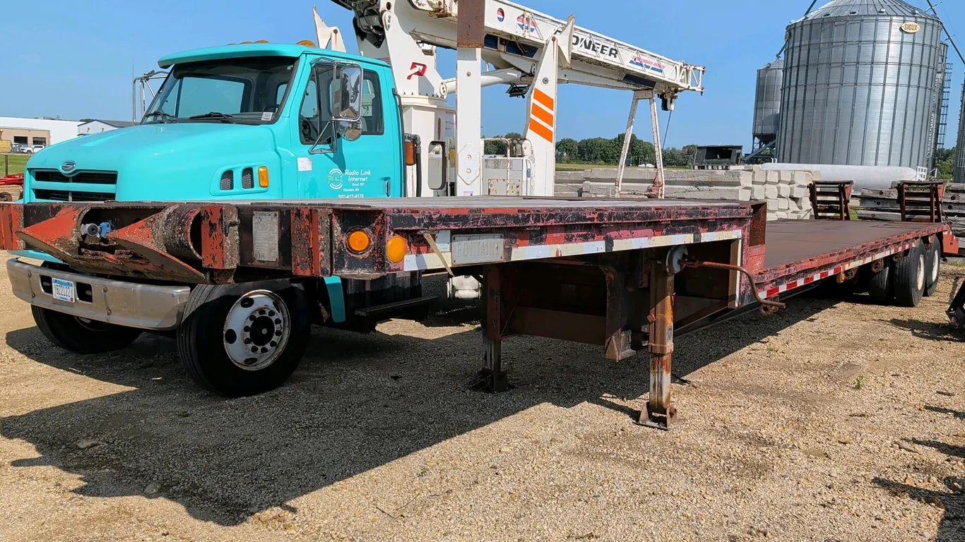 1981 Fontaine FDT-1-40 drop deck semi trailer. Features a 70,000 lb capacity frame rating, beaver tail with fold-down ramps, metal main deck, and wood