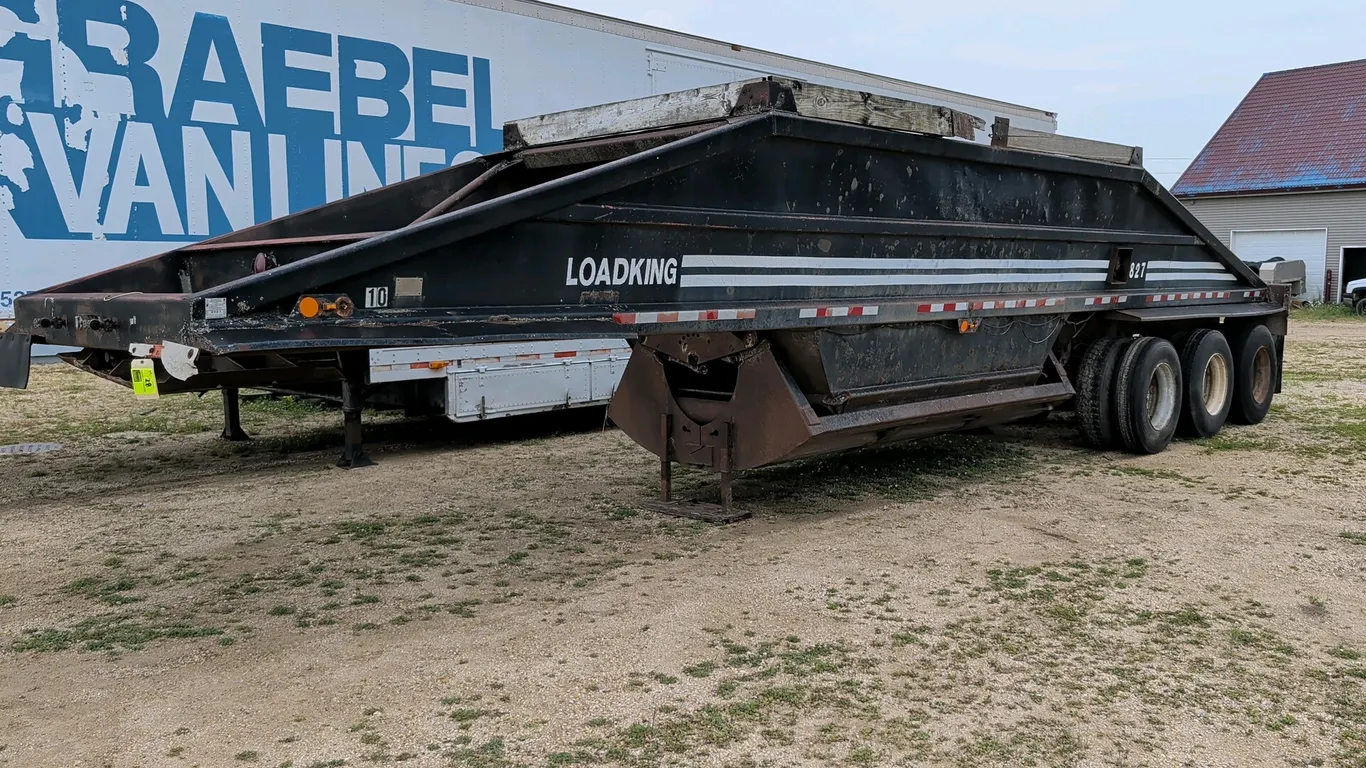 1983 Loadking belly dump gravel trailer. Features triple-axle configuration, bottom discharge gate with pneumatic cylinder, leaf spring suspension, an