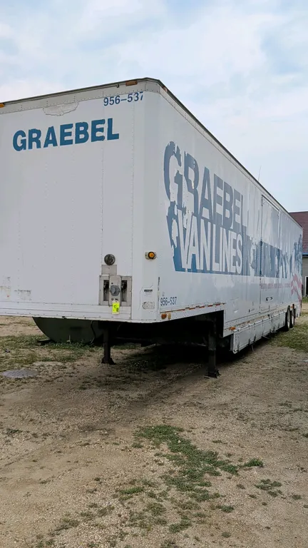 1992 Kentucky moving van trailer. Features multiple side access doors, lower storage compartments, rear swing doors, and interior cargo control tracks