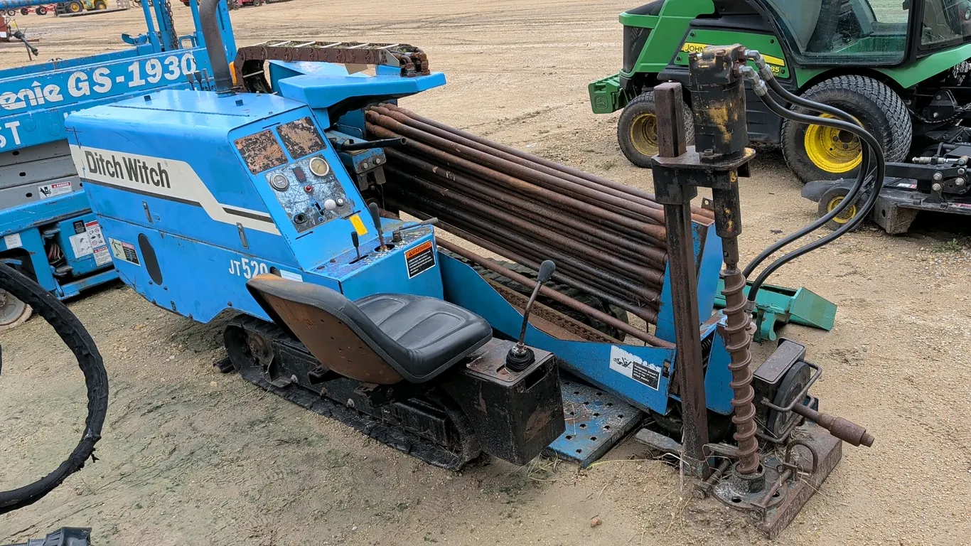 1999 Ditch Witch JT520 horizontal directional drill. Features loaded drill pipe rack, operator station with controls, and hydraulic anchoring system.