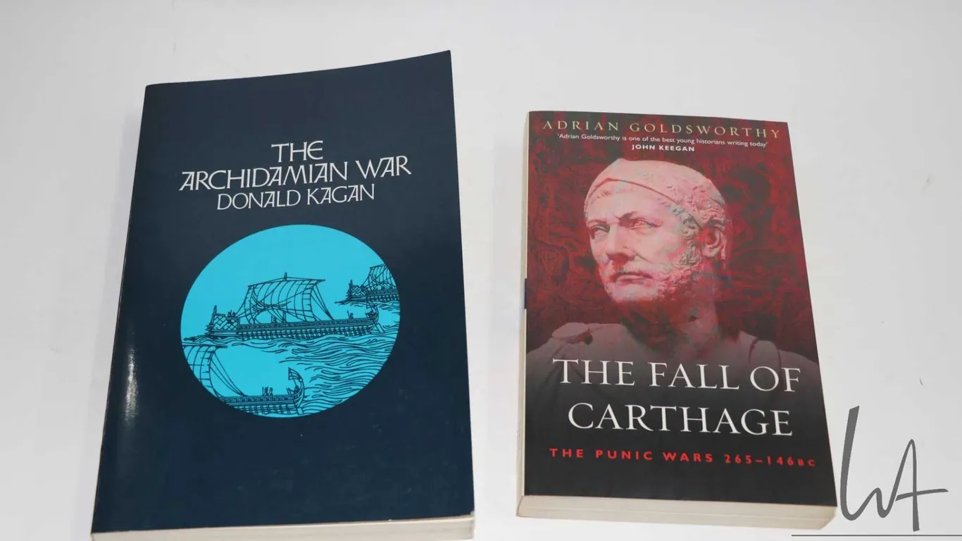Two softcover books including "The Archidamian War" by Donald Kagan and "The Fall of Carthage: The P