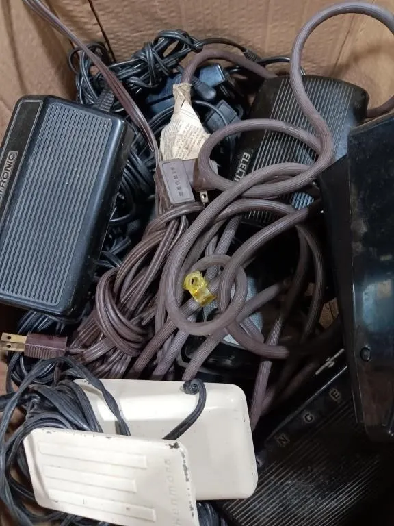 Box of old sewing machine pedals