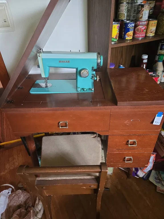 Vintage white sewing machine in cabinet