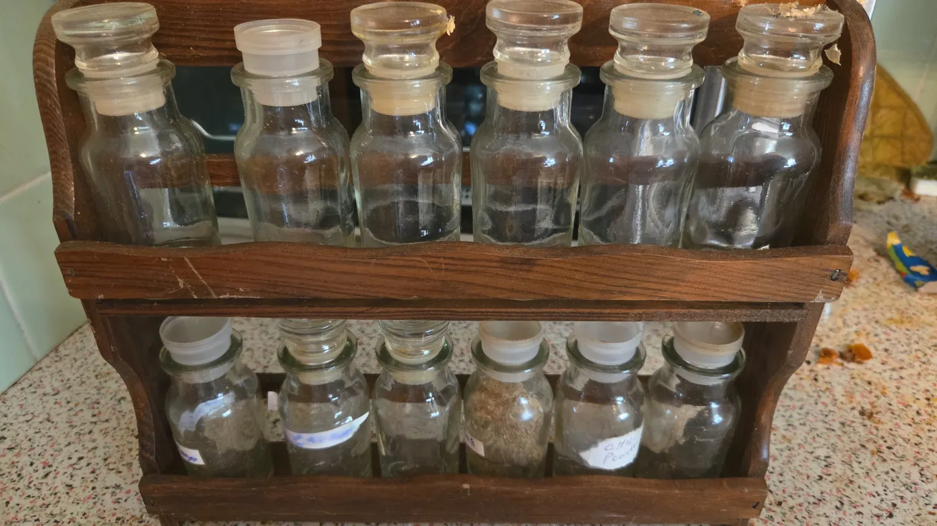 Vintage wooden spice rack and 12 glass jars.