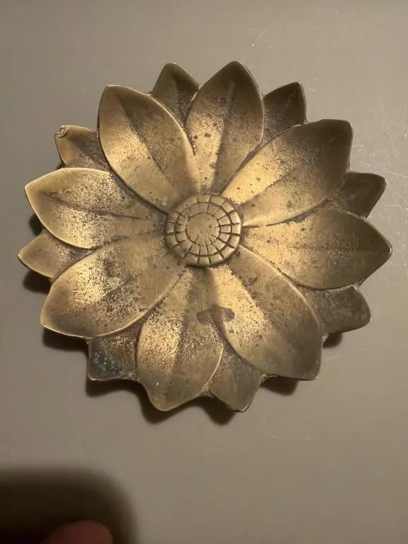 This brass lotus-shaped incense holder features