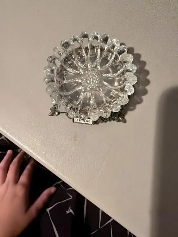 This vintage glass ashtray features a detailed