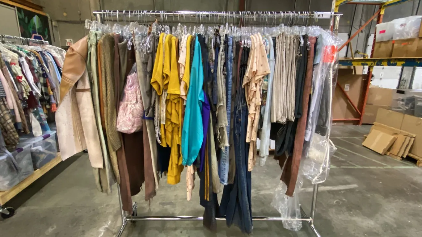 MOBILE WARDROBE RACK FILLED WITH ASSORTED CLOTHING