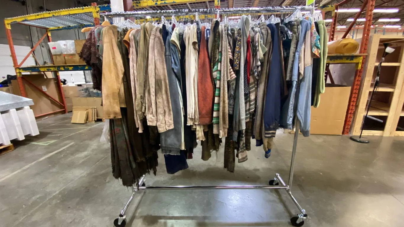 MOBILE WARDROBE RACK FILLED WITH ASSORTED CLOTHING