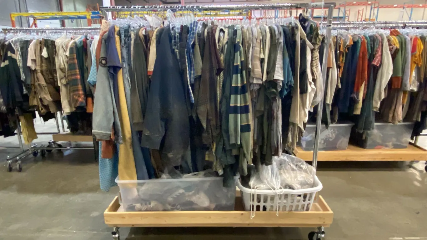 MOBILE WARDROBE RACK FILLED WITH ASSORTED CLOTHING