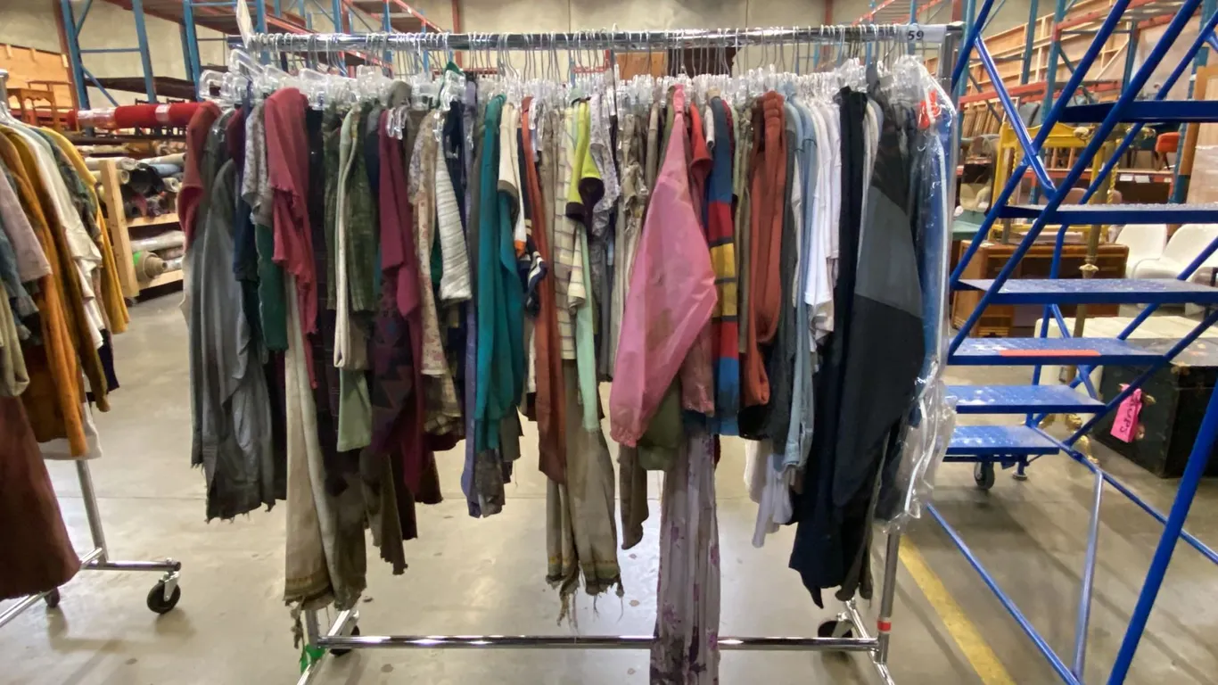 MOBILE WARDROBE RACK FILLED WITH ASSORTED CLOTHING