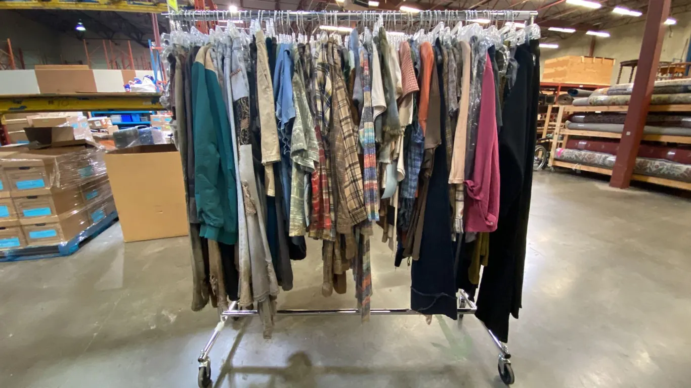 MOBILE WARDROBE RACK FILLED WITH ASSORTED CLOTHING