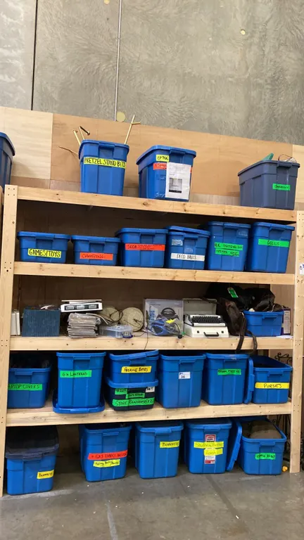 5 SHELVES OF RUBBERMAID BINS FILLED WITH ASSORTED ITEMS - PURSES, DOLLS, LANTERNS, CAMPING
