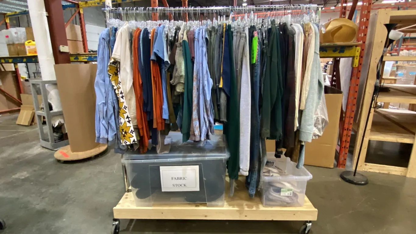 MOBILE WARDROBE RACK FILLED WITH ASSORTED CLOTHING